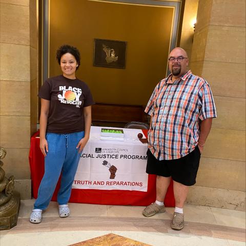 Rev. Jim Bear Jacobs, Co-Director of Racial Justice, and Racial Justice Administrative Assistant Phoebe McGowan in front of the MCC table in the Capitol Rotunda