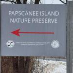 A sign read "Papscanee Island Nature Preserve" above a red left-pointing arrow. On the bottom fo the sign is the official seal fo the Stockbridge-Mundsee Band of Mohicans.
